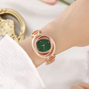 Elegant roségouden kwartshorloge met groene strass-wijzerplaat om de pols van een vrouw
