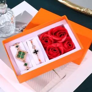 Luxury women's quartz watch set with clover dial, bracelet, and roses in orange gift box