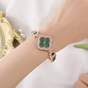 Close-up of luxury rose gold clover watch with green dial and diamond accents for women