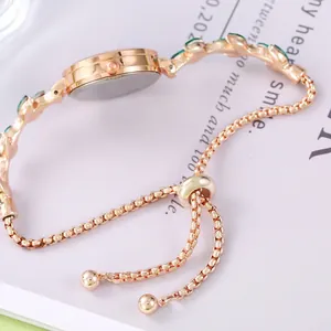 Montre bracelet élégante en or rose avec pierres vert émeraude et fermoir ajustable