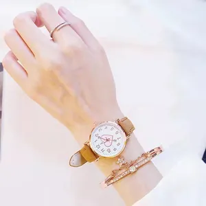Detail of rose gold watch with heart dial and matching star charm bracelet on wrist