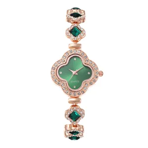 Detail of rose gold clover watch with green dial and sparkling crystals set in links