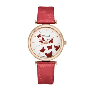 Detailed view of rose gold quartz watch featuring red butterfly patterns and leather strap