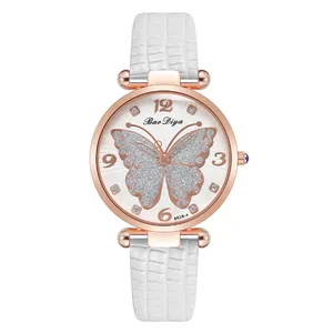 Detail of rose gold watch dial featuring a silver glitter butterfly and white leather strap