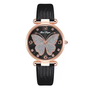Close-up of rose gold watch dial with silver glitter butterfly and black leather strap