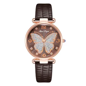 Macro detail of brown leather watch strap with crocodile texture and glittery butterfly dial