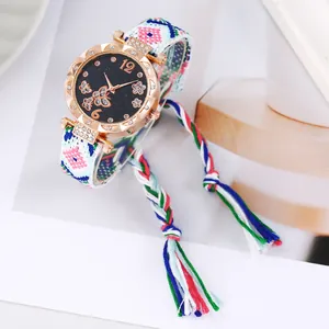 Detail of rose gold watch with starry butterfly dial and colorful woven fringe strap