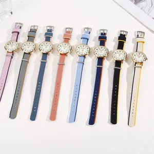 Flat lay of eight colorful nylon strap quartz watches with gold circular cases