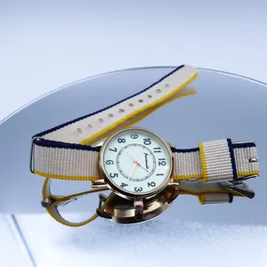 Luminous quartz watch with colorful nylon NATO strap and gold metal case on a blue background