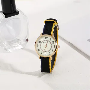 Detail of round gold quartz watch with striped nylon strap and Arabic numeral dial