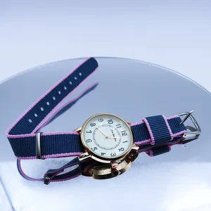 Close-up of a stylish NATO nylon strap watch on a reflective mirror surface