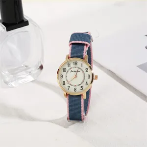 Close-up of a rose gold quartz watch with a blue and pink striped nylon fabric strap