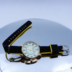 Detailed view of casual quartz watch with gold case and striped nylon NATO strap on mirror