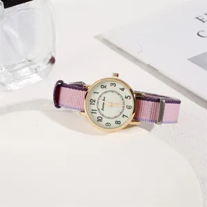 Detail of a minimalist gold watch with a purple, pink, and light blue nylon fabric strap
