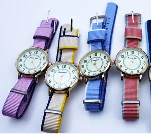 Close-up of vibrant nylon straps and gold quartz watch dials with Arabic numerals