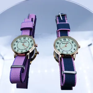 Detailed macro shot of dual quartz watches with NATO striped nylon straps on mirrors