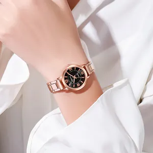 Détail d'une montre à quartz en or rose avec cadran noir et bracelet métallique