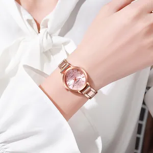 Montre à quartz élégante en or rose pour femme avec cadran rose portée au poignet