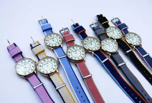 Detailed overhead view of eight colorful NATO nylon strap quartz watches with rose gold cases