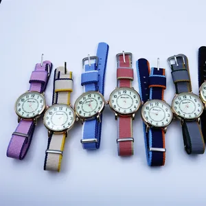 Detailed flat lay of nylon NATO strap watches with gold cases and quartz dials