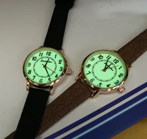 Close-up of luminous watch dials with large Arabic numerals and rose gold cases