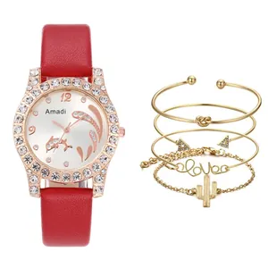 Nahaufnahme der roten Uhr mit Delfin-Zifferblatt und vier goldfarbenen Armbändern