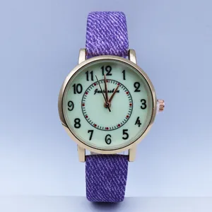 Detail view of the purple denim texture strap and gold case of this quartz watch