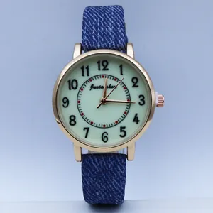 Macro detail of casual quartz watch with luminous green dial and blue denim strap