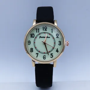 Close-up of vintage gold quartz watch with black Arabic numerals and leather strap