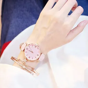 Detailopname van roze leren horloge met strass wijzerplaat en roségouden sterarmband
