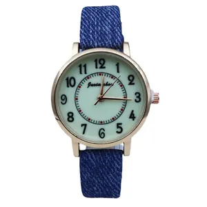 Vintage women's quartz watch with dark blue denim strap and golden case in white background