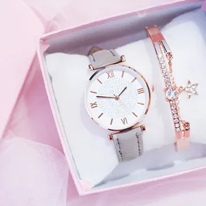 Primo piano del set orologio e bracciale in oro rosa con strass in una confezione regalo