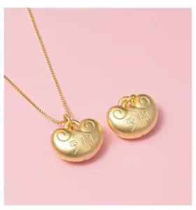 Macro shot of matte gold Ruyi lock pendants featuring traditional Pingan characters