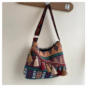 Λεπτομερής προβολή της boho τσάντας με πολύχρωμες φούντες και υφαντά σχέδια