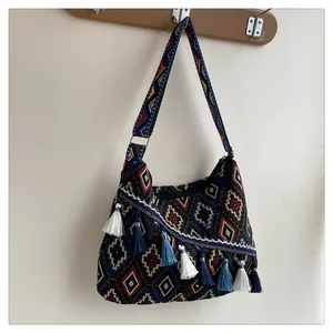 Λεπτομέρεια boho τσάντας με φούντες με υφαντά γεωμετρικά σχέδια και κρεμαστά κρόσσια