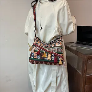 Ethnic μποέμ τσάντα με γεωμετρικά σχέδια ζακάρ και πολύχρωμα διακοσμητικά φούντες