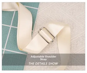 Close-up of cream-white adjustable woven shoulder strap with polished silver metal buckle