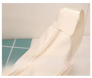 Detail view of durable zipper and stitching on a beige waterproof crossbody dumpling bag