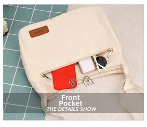 Front zipper pocket of beige crossbody bag showing space for phone and power bank