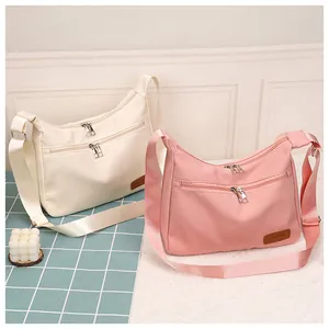Detail of waterproof nylon crossbody bags with dual zippers and adjustable wide straps