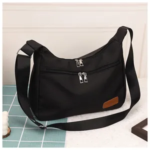Detail of waterproof nylon dumpling bag with double zippers and fashion logo patch