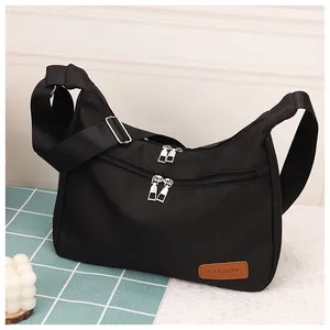Detail of black waterproof crossbody bag with dual zippers and adjustable wide strap