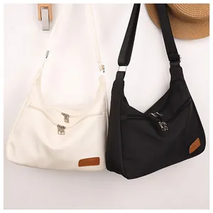 Detail of waterproof nylon crossbody bags with multiple zip pockets and fashion patch