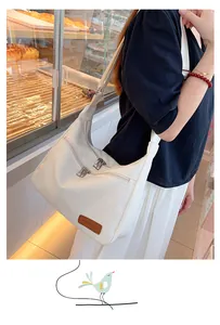 Detail of white large capacity shoulder bag with metal zippers and fashion leather patch
