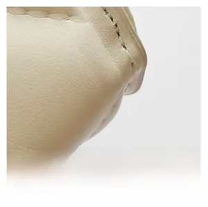 Close-up of beige diamond quilted leather showing precise stitching and smooth texture