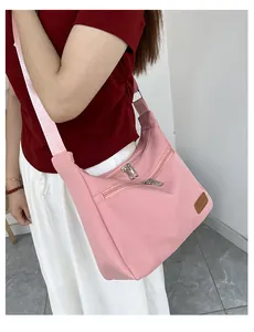 Detailed view of the pink waterproof nylon dumpling bag with dual zipper outer pockets