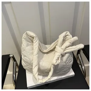 Detail of off-white quilted cloud bag with knot strap and textured nylon fabric finish