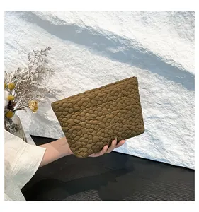 Detailed view of the large capacity envelope clutch with 3D floral quilted texture