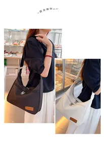 Detail view of large nylon crescent bags in black and beige with fashion leather patch