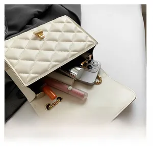 Capacity display of the beige quilted crossbody bag showing interior and chain strap
